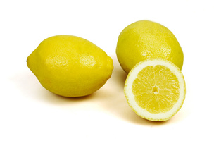 Drei Zitronen, zwei ganz und eine halbiert, auf weißem Hintergrund.