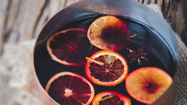 Ein Glas mit Punsch oder Glühwein, dekoriert mit Orangenscheiben.