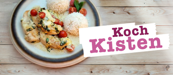 Ein Teller mit einer fertig zubereiteten Mahlzeit, bestehend aus Hähnchenfilet mit Kirschtomaten und Kräutern, serviert mit Reis, daneben ein Schriftzug 'Kochkisten' auf einem Holzuntergrund, der auf die Möglichkeit hinweist, solche Mahlzeiten durch gelieferte Kochboxen zuzubereiten