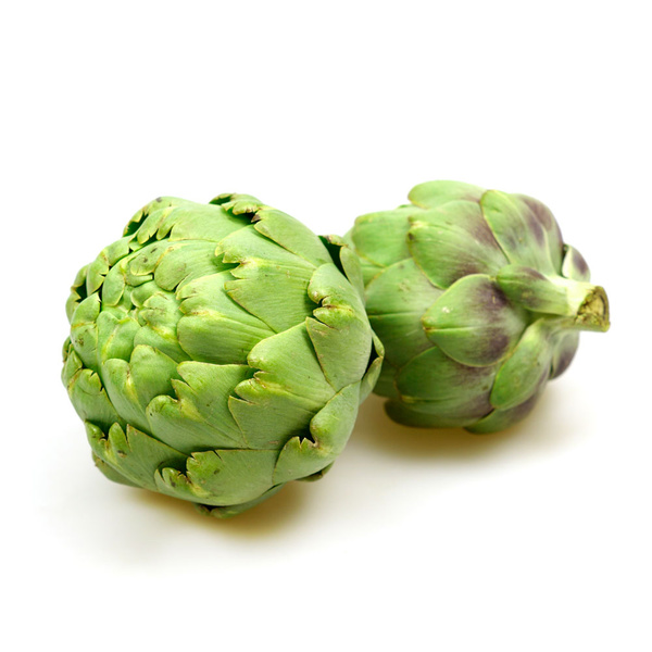 KI generiert: Zwei frische Artischocken vor weißem Hintergrund.