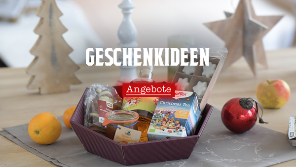KI generiert: Geschenkset auf einem Tisch mit weihnachtlicher Dekoration. Text: "GESCHENKIDEEN Angebote".